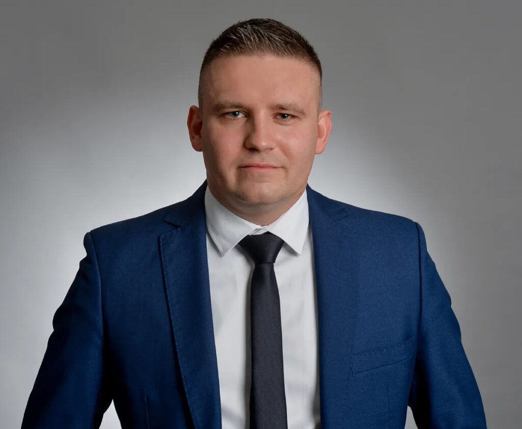 Mężczyzna w garniturze doradza w kwestiach związanych z kredytem na mieszkanie.